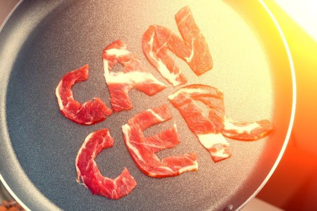 אילוסטריה, בשר אדום על מחבת על ידו כתובה המילה סרטן, ממחיש את העובדה שצריכה של בשר אדום מעלה את הסיכוי להתפתחות של סרטן